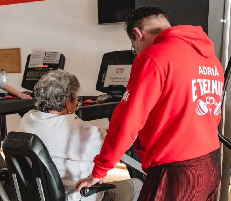 Un entrenador d'Eternal Gym acompanyant una sòcia a la zona de cardio